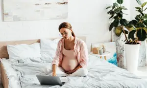 Ciężarna kobieta w okularach szuka informacji o wada wzroku a poród naturalny.