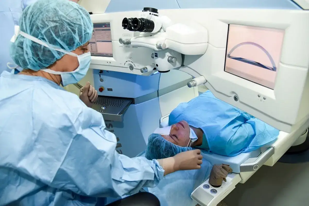 Chirurg przygotowuje pacjenta do zabiegu laserowego oka, by skorygować astygmatyzm po operacji zaćmy. Na ekranie widoczny jest schemat oka.