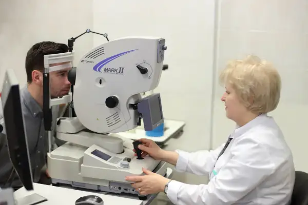 Badanie okulistyczne z użyciem angiografii fluoresceinowej. Lekarz bada pacjenta, monitorując potencjalne skutki uboczne.